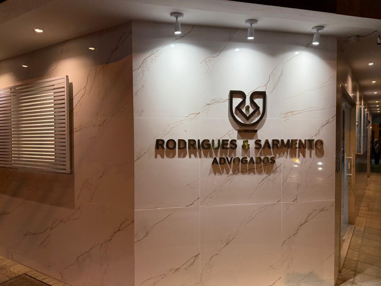 Recepção do escritório com o logotipo em relevo sobre parede de mármore